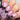 Hand with pink nails holding a bottle of nail polish.