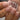 Close-up of a hand with nude blush pink nail polish holding a bottle of nail polish.