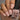 Hand with nude pink nail polish holding a bottle of 'Hit the Bottle' nail polish.