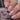 Nail polish bottle with a hand holding a pink manicured nail