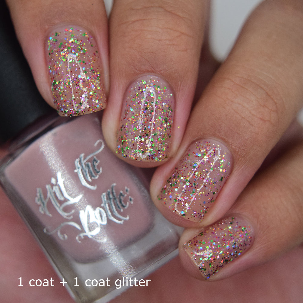 Nails with glittery nail polish over nude peel off base coat in blush colour.