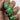 A close-up of a hand showcasing manicured fingernails with a green and black spider-themed Halloween design, featuring spiderwebs and spider faces over a black to green gradient base.