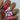 A close-up of a hand showcasing manicured nails with a pink and white nail art design. Two nails are solid glossy hot pink, while the other two are white with a repeating pattern of pink lips with black outlines.