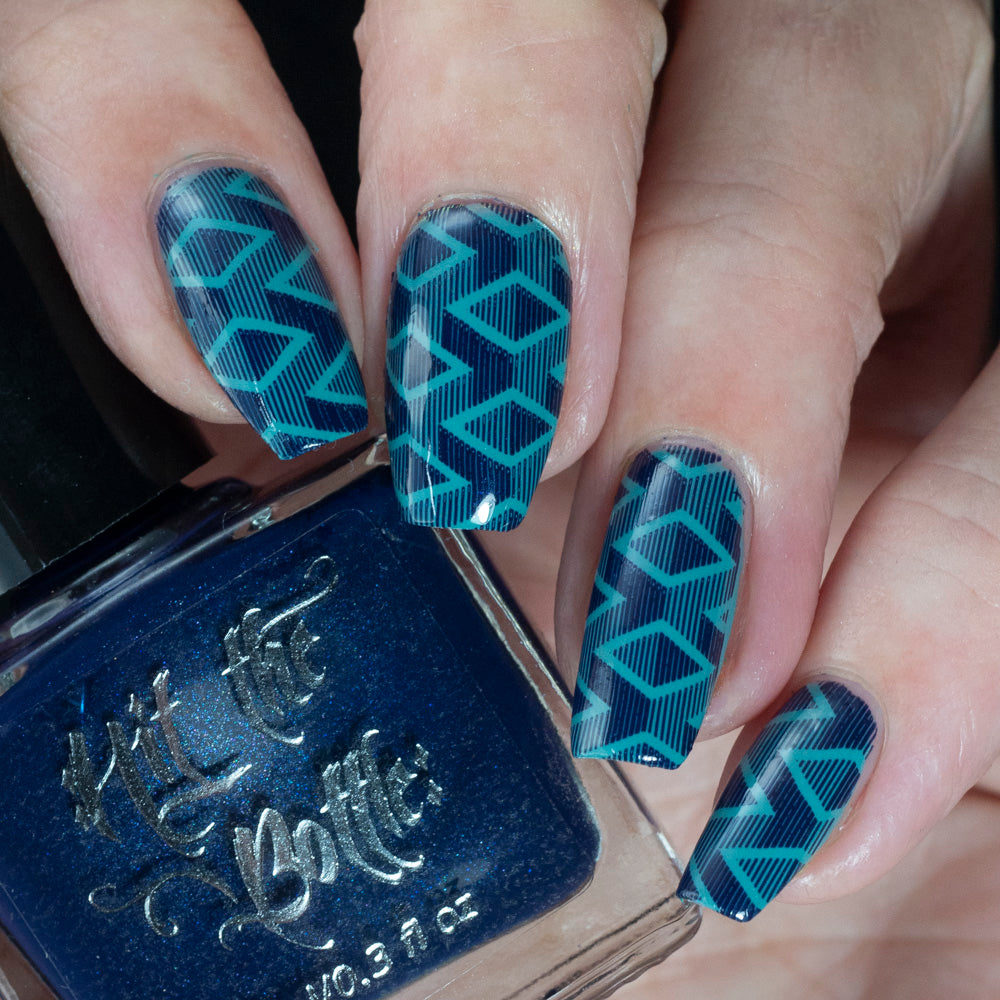 Nails with blue geometric pattern and bottle of blue nail polish