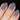 Close-up of a hand with gray nail polish on a black background