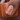 Nail with orange and white pattern held against an orange background