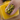 Nail with black and yellow pattern held by a hand against a yellow background