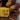 Nail polish bottle with yellow and black patterned nails