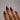 Hand with purple and blue gradient nail polish on a neutral background