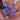 Nail polish with purple and blue glittery finish held by a hand