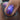 Close-up of a hand with purple glittery nail polish holding a nail polish bottle.
