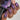 Nail polish with a metallic purple finish applied to nails, held by a hand.