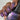 Nail polish with glittery purple and blue color held by a hand